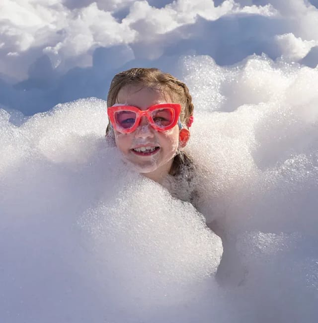 Girl peeking through deep foam at an outdoor party
